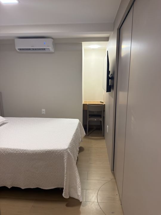 Cama de casal com ar-condicionado e escrivaninha ao fundo
