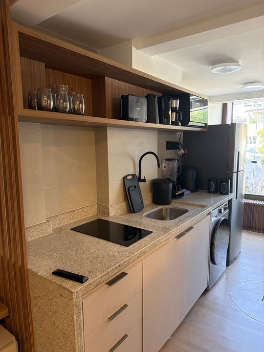 Cozinha com cooktop, bancada de granito e armários