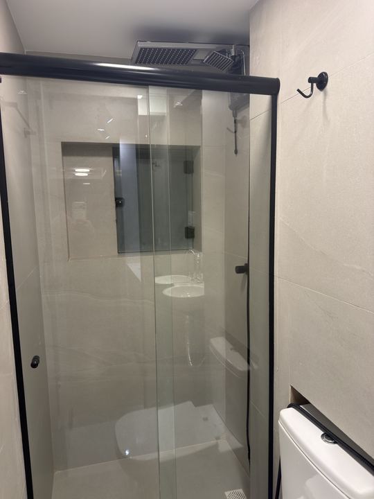 Box de vidro com ducha e vaso sanitário