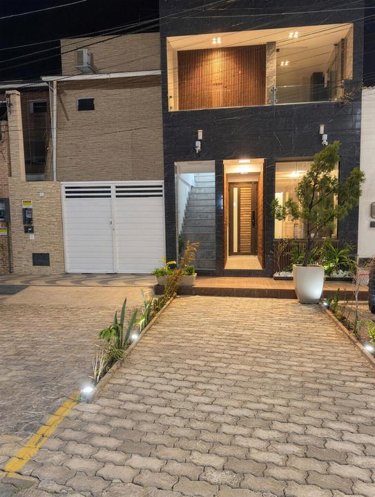 Fachada do prédio com revestimento escuro e porta de madeira